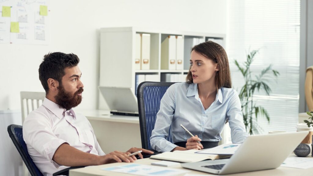 two-colleagues-discussing-business-office
