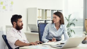 two-colleagues-discussing-business-office